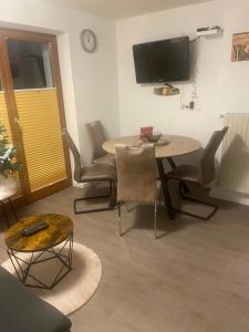 a living room with a table and chairs and a television at Appartement Wanneck in Biberwier