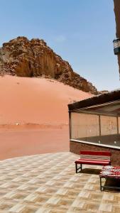 a red bench sitting next to a building in the desert at Rest luxury camp in Disah