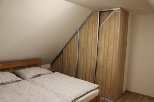 1 dormitorio con cama y armario de madera en Apartmány 264, en Albrechtice v Jizerských horách