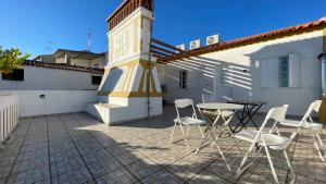 een patio met stoelen en een tafel voor een gebouw bij Pátio do Alqueva - Alojamento Local in Granja