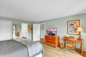 Dormitorio con cama, escritorio y TV en Blue Heron, en Harrington
