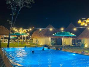 a swimming pool at night with umbrellas at SEA SAND RESORT in Kampot