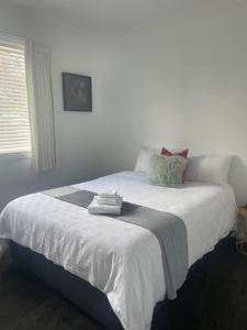 - une chambre avec un grand lit blanc et des serviettes dans l'établissement The Dale 1974, à Lilydale
