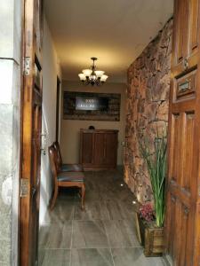 a hallway with a chair and a stone wall at Hotel Casa Posos in Guanajuato