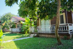 a house with a white porch and a tree at Apella Hotel in Cıralı