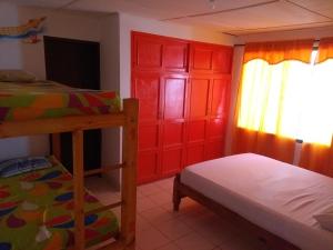 a bedroom with two bunk beds and a red cabinet at Taganga Paradise Hostal Diving in Taganga
