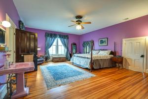 um quarto com paredes roxas, uma cama e um lavatório em Historic Chambersburg Home with Pool and Game Rooms! em Chambersburg