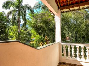 d'un balcon avec vue sur un palmier. dans l'établissement Gruta d'ouro Pousada, à Prados
