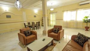 a living room with a couch and chairs and a table at Le VIP du Petit Génie in Yaoundé