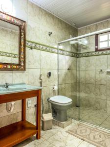 La salle de bains est pourvue d'une douche, de toilettes et d'un lavabo. dans l'établissement Gruta d'ouro Pousada, à Prados