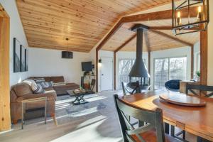 a living room with a wooden ceiling and a table at Rustic Getaway with Fireplace - Walk to Slopes! in Lyndhurst