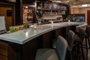 a bar with chairs and a counter with wine glasses at Courtyard Chicago St. Charles in Saint Charles