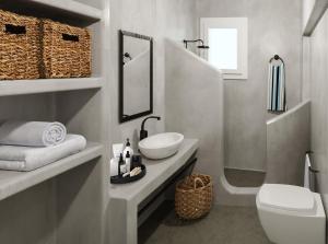 a white bathroom with a sink and a toilet at Mykonos Residence Villas & Suites Merchia Beach in Merchia Beach