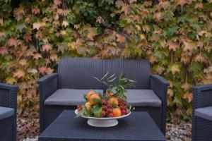 a bowl of fruit on a table with a chair at SyracuseApartments Antica Dimora in Siracusa