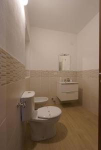 a bathroom with a white toilet and a sink at SyracuseApartments Antica Dimora in Siracusa