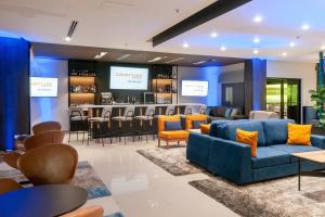a lobby with couches and chairs and a bar at Courtyard by Marriott San Salvador in San Salvador