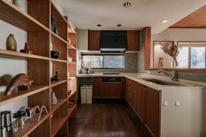 a kitchen with wooden cabinets and a sink at AMAO VILLA 熱海 in Atami