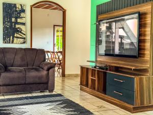 sala de estar con sofá y TV de pantalla plana en Gruta d'ouro Pousada, en Prados