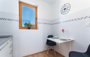 a small white kitchen with a small table and a window at Apartments Viktor in Poreč +17 photos