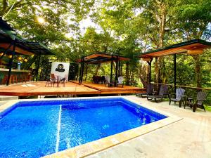 een zwembad met een terras en een patio bij Jungle Beach Hotel Manuel Antonio in Manuel Antonio
