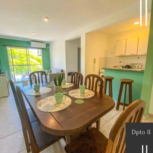 a dining room and kitchen with a wooden table and chairs at Departamento Good Vibes 2 in Paraná