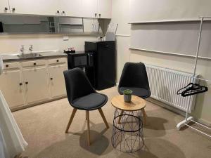 a kitchen with two chairs and a table and a refrigerator at Elliston Cottage North Hobart x 2 in Hobart
