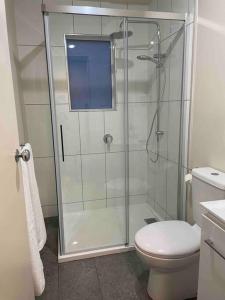 a bathroom with a glass shower with a toilet at Elliston Cottage North Hobart x 2 in Hobart