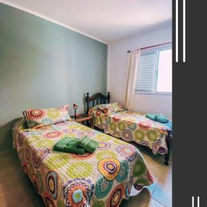 a bedroom with two beds and a window at Departamento Good Vibes 2 in Paraná