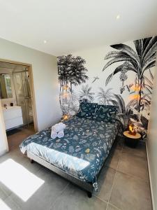a bedroom with a bed with a mural of palm trees at Villa Ti Lagon in Sainte-Luce