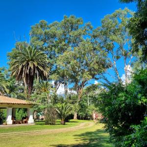 un giardino alberato e una casa di Posada El Prado a Salta