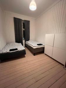 two beds sitting in a room with wooden floors at Rom midt i Oslo sentrum - Gå avstand til det meste in Oslo