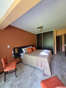 a bedroom with a large bed and a chair at Aires de las Sierras in Sierra de la Ventana