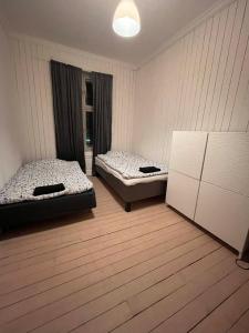 2 letti posti in una stanza con pavimenti in legno di Rom midt i Oslo sentrum - Gå avstand til det meste a Oslo