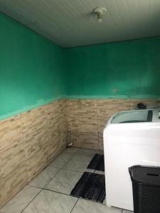 une chambre avec un mur vert et un lave-linge dans l'établissement Aluguel casa para temporada, à Itapema