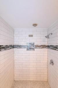 a bathroom with white tiled walls and a shower at High Rise Downtown Condo With Skyline View in Atlanta