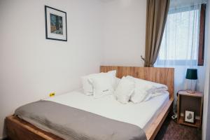 a bedroom with a bed with white sheets and pillows at Valea lui Liman in Tomeşti
