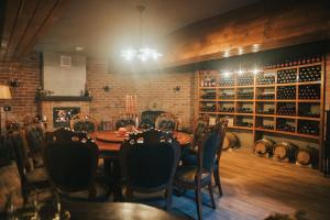 a dining room with a table and chairs and wine racks at Valea lui Liman in Tomeşti