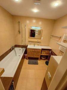 ein Badezimmer mit einer Badewanne, einem Waschbecken und einem Spiegel in der Unterkunft Downtown Apartment Bianca in Bratislava