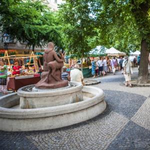 a statue of a person sitting on a fountain in a park at Downtown Apartment Bianca in Bratislava