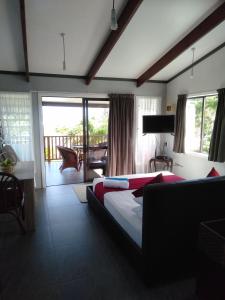 Cette chambre d'hôtel comprend un lit et un balcon. dans l'établissement Te Moana Nui Villa 2, à Arorangi