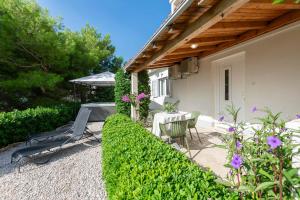 a patio of a house with a table and chairs at Apartments Olive sea view in Mimice