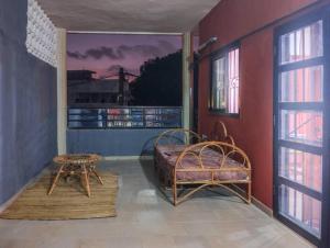 een slaapkamer met een bed en een tafel en ramen bij Appartement cosy Cotonou 1 chambre in Cotonou