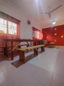 een kamer met een houten tafel en rode muren bij Appartement cosy Cotonou 1 chambre in Cotonou