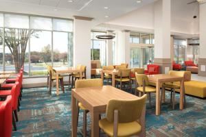 un comedor con mesas, sillas y ventanas en Hilton Garden Inn Solomons, en Dowell