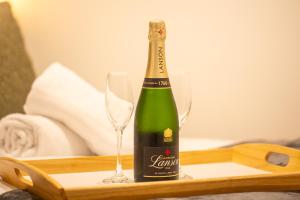 a bottle of champagne and two glasses on a tray at Peaceful one bed flat in Stockport centre in Stockport