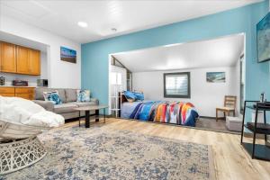 a bedroom with blue walls and a bed and a couch at Sonoma Coast Retreat - Water Views BBQ WIFI in Bodega Bay