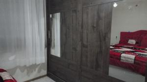 um quarto com uma grande porta de madeira e uma cama em Recanto dos pássaros em Bombinhas