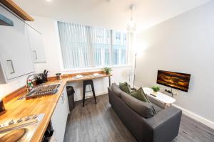 sala de estar con sofá y cocina en Peaceful one bed flat in Stockport centre, en Stockport