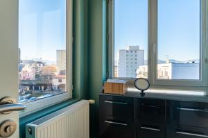 a room with two windows and a dresser with a mirror at La Casa de Hugo in Colmar