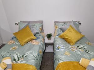 twee bedden naast elkaar in een kamer bij Deluxe apartment Sleeps up to 6 in Leicester